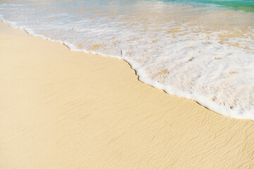 A sandy beach with waves crashing, showcasing the beauty of water and nature
