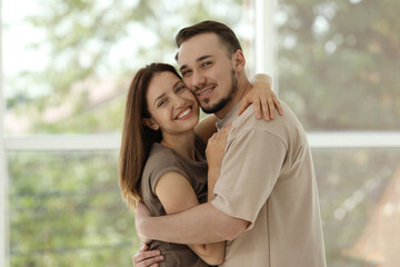 Obraz premium Portrait of happy couple hugging at home