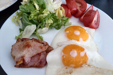 Fresh Breakfast Plate with Bacon, Sunny Side Up Eggs, and Salad - Perfect Meal for a Healthy Start