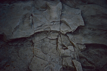 Naklejka premium Black rock texture, darkened background of a black rock wall