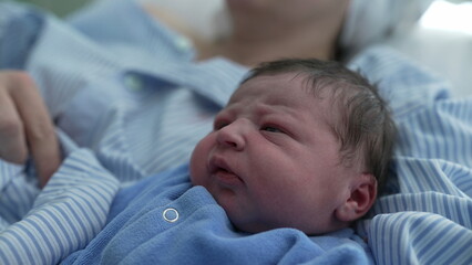 Newborn baby close-up in serene contemplation after childbirth, first day of infant's life resting...