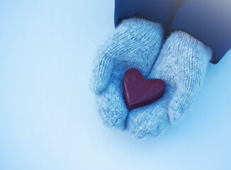 Obraz premium Female hands in mittens with heart, close-up