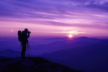 Fototapeta premium Silhoutte of photographer with him camera in mountains and beautiful purple sunset
