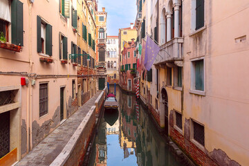 Traditional old Venetian houses over canal and gondolas on sunny day, Venice, Italy