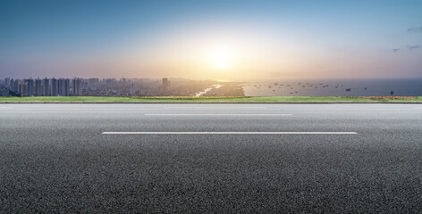 Urban Road Leading to Coastal City at Sunset