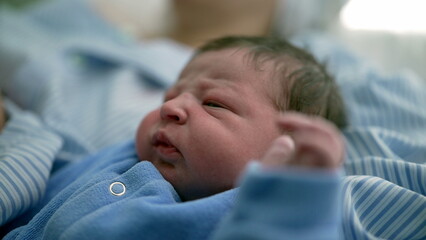 Newborn baby's hand closeup during first day of life, infant observing world for the first time, cute detail