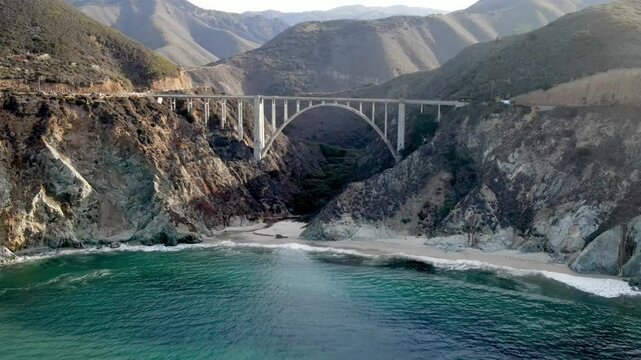 Aerial of the rugged coastline of Big Sur California. The Pacific Coast Highway and the famous Bixby Creek Bridge can be seen.