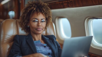 Businesswoman Working On Laptop While Traveling In Private Jet