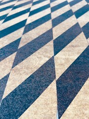 Fototapeta premium A yellow and black caution paint sidewalk crosswalk ensures pedestrian safety with bold, high-contrast stripes, clearly marking crossing areas and enhancing visibility for both walkers and drivers.
