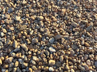 An overhead view of colorful pebble rock stones displays a vibrant mosaic of shapes and hues, creating a visually striking and texturally rich natural pattern.