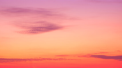 Colorful orange sunset sky in the evening with dark cloud streaks on beautiful sunrise sky background, Idyllic natural tranquil scene