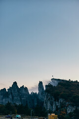 Obraz premium Scenic Mountain View from Road in Front of FlagTopped Building Travel Destination Inspiration with Business Potential