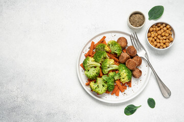 Healthy food broccoli, carrots and vegetable meatballs on a plate top view on a white background with copy space