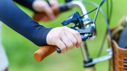 child hand pressing the hand brake on a bicycle, learning bike safety and control with hands-on experience in cycling adventures