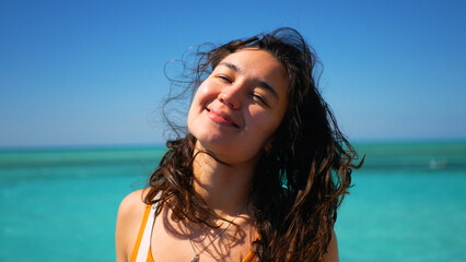  Portrait of a young attractive girl against the background of the ocean.