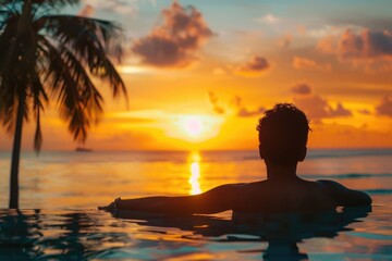 Fototapeta premium relaxation on the beach young man enjoying beautiful sunset in luxury hotel near swimming pool