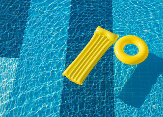 floating ring and a mattress on the blue water of the pool