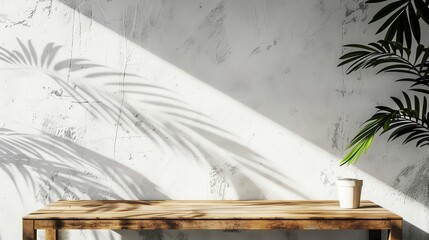 Empty wooden table with tropical plant shadows on white wall. Minimalist background for product display with sunlight and copy space.