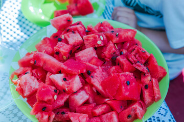 View of plate on table with sliced pieces of ripe red watermelon.