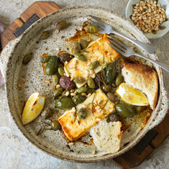ceramic dish with baked feta and olives, top view