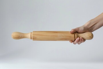 Woman hand holding a wooden rolling pin on a white background