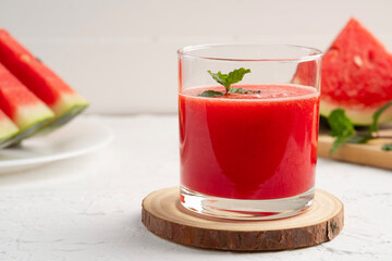Watermelon smoothie topping with fresh mint leaves on white wood background.Healthy drink.