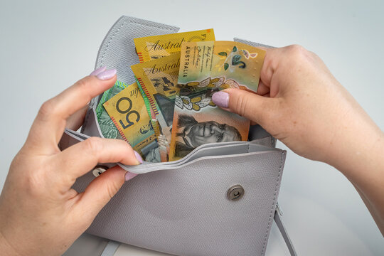 woman hold australian dollar paper bank note cash bills with grey bag. Rremoving money from wallet