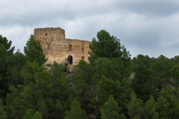 Paisaje con nubes en el bosque y edificación medieval en ruinas entre pinos, Alcoy, España