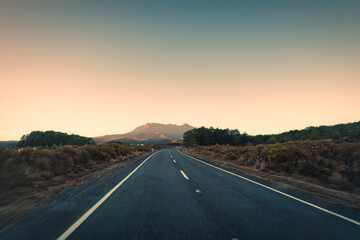 Road trip with golden sunrise over volcanic mountain on wilderness