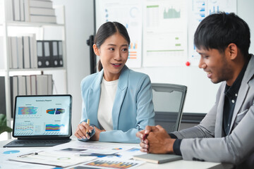 Asian businesswoman explaining charts to her male colleague during a meeting