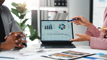 Business team analyzing financial data using digital tablet during meeting