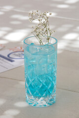 Blue Lagoon Cocktail, Angelo azzurro cocktail in tall glass on the table in the beach bar