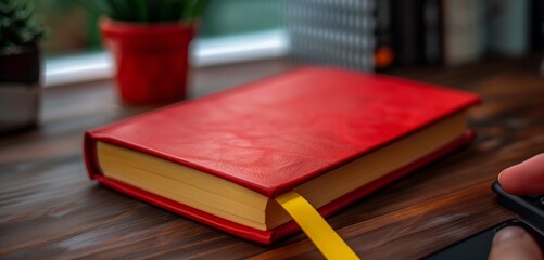 Simple red book with a yellow bookmark on a minimalist desk, symbolizing a fresh start to the school year after summer.