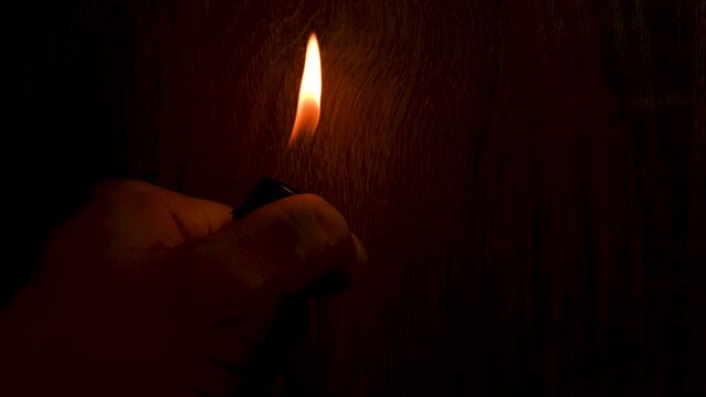 Fire, a lighter flame in the dark. Lighter flame.