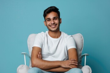 A person sitting in a chair with their arms crossed, potentially conveying a sense of relaxation or contemplation