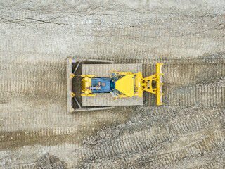 Aerial view of bulldozer working in mine. Heavy machinery for earth moving. © Mario