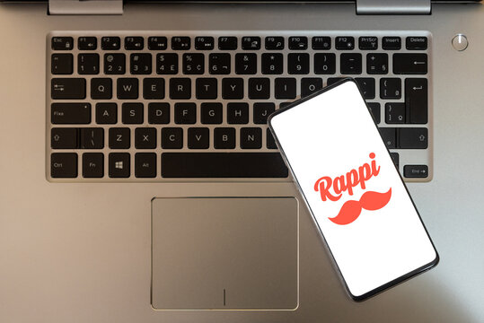 cell phone with the Rappi logo on top of the notebook