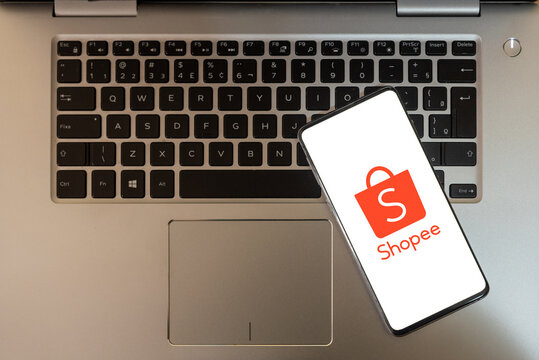 cell phone with the Shopee logo on top of the notebook