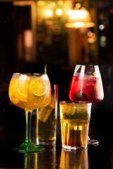 set of drinks of various sizes and refreshing and tropical colors on a dark blurred Irish night background