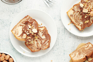 A piece of marble biscuit with chocolate cream and nuts