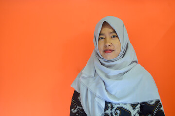 Portrait of an Asian Muslim woman in casual style on an isolated orange background