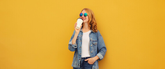 Modern stylish happy young woman drinking coffee posing on bright yellow background