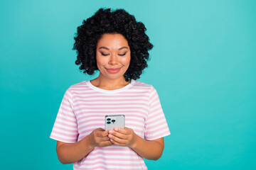 Portrait photo of young happy girlfriend in striped t shirt using smart phone communicating isolated on aquamarine color background