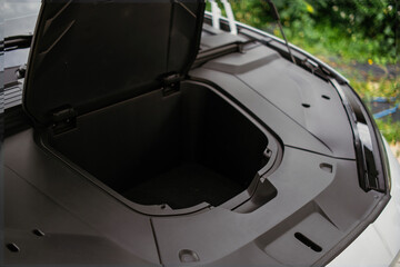Fototapeta premium front trunk (frunk) of an electric vehicle with the hood open,revealing an empty storage compartment.
