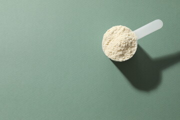 Spoon with protein on colored background