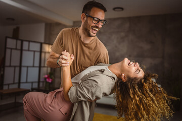 Fototapeta premium Happy in love couple man woman husband and wife dance at home have fun