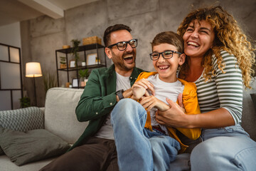 happy family of three have a fun at home tickle son and hug each other