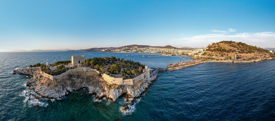 Kusadasi, Aydin, Turkey. Guvercinada Island (Pigeon Island) and Guvercinada Castle with Kusadasi city background. Kusadasi is a popular tourist destination in Turkey. Drone shot.