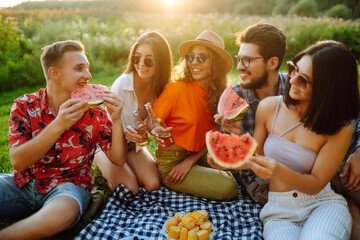 Young cheerful friends happy positive smile eat fruit watermelon party countryside outdoors. Foods, travel, nature and picnic concept