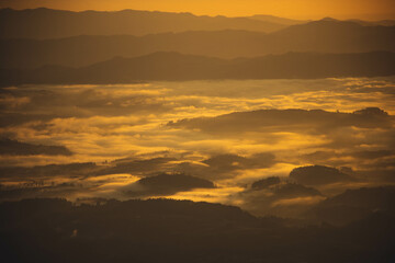 a beautiful landscape of an orange sunrise in the foggy mountains - Serra do Rio do Rastro, SC - Brazil